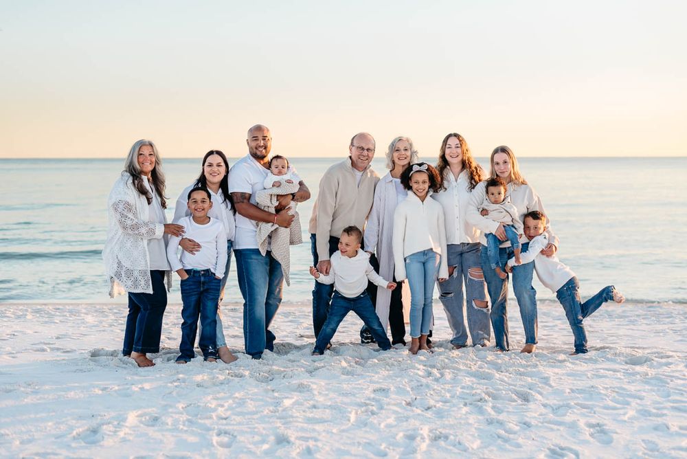 Beautiful family of 12 gathered together on the pristine beaches of Henderson Beach State Park during Golden Hour.