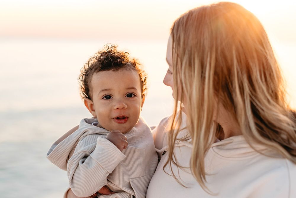Child playing as mother holds him admiring the beautiful scenery of the emerald coast.