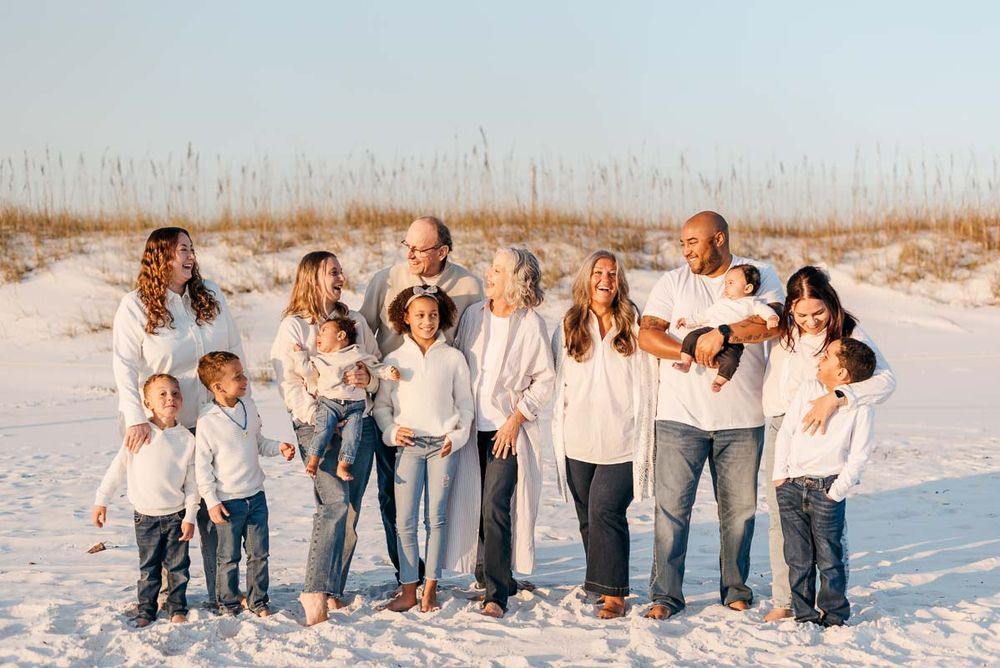 Gorgeous family of grand parents, parents, and children ready to take their family photos on the beaches of Miramar Florida during sunset.