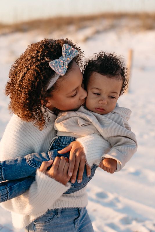 Siblings love between each other during sunset on the powder white sands of Destin Florida.