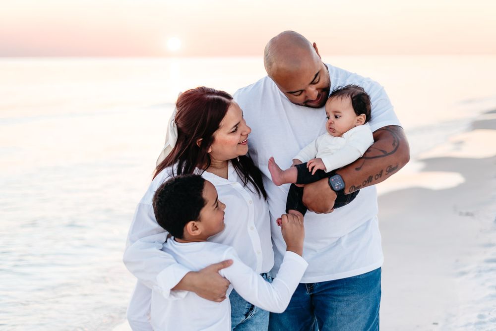 Naturally lit family photo of Parents and their two kids during sunset time at Henderson Beach State park