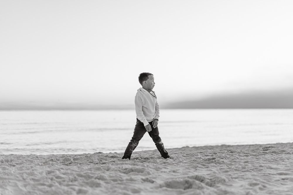 Black and white image of a young child enjoying the beach time during Christmas vacation.