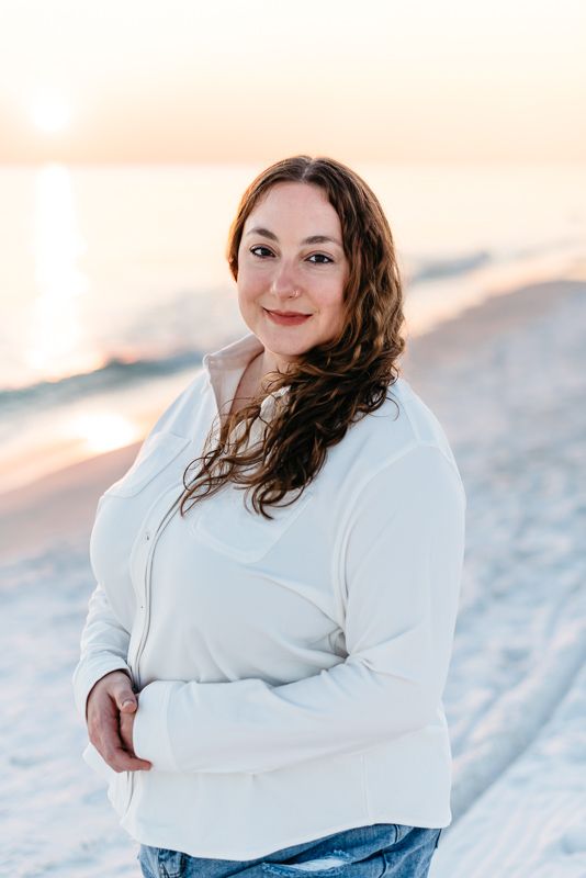 Portrait of a young mother on the beach with a golden yellow glow from the sunset behind her