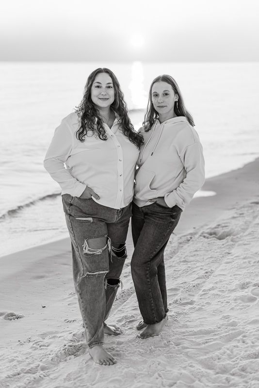 Black and white image of two sisters looking into the camera during their family photo session