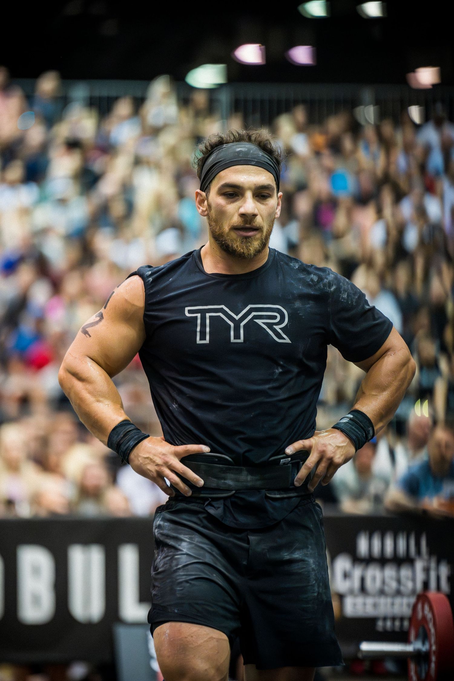 Athletic competitor in TYR black shirt poses during CrossFit competition.
