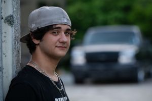 A casual portrait of someone wearing a gray baseball cap against a blurred background.