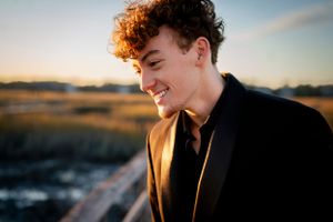A sunset portrait showing a joyful expression in formal attire.