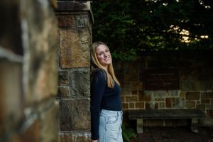 Evening portrait against stone wall with natural lighting.