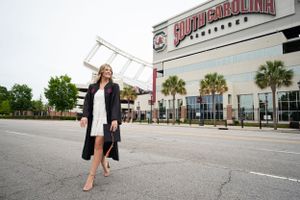 Graduation photo outside Williams-Brice Stadium in academic regalia.