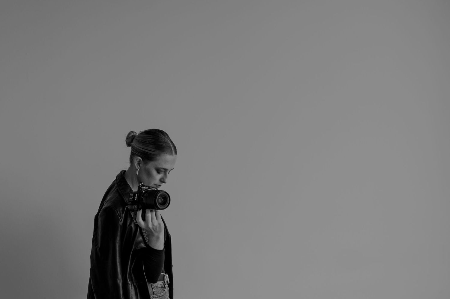 A dramatic black and white profile portrait showing contemplative downward gaze.