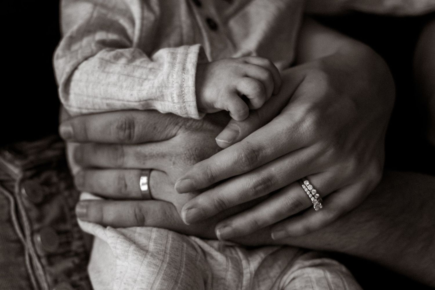 Close-up of parents holding hands with newborn baby | Storytelling detail photography in Tampa Bay