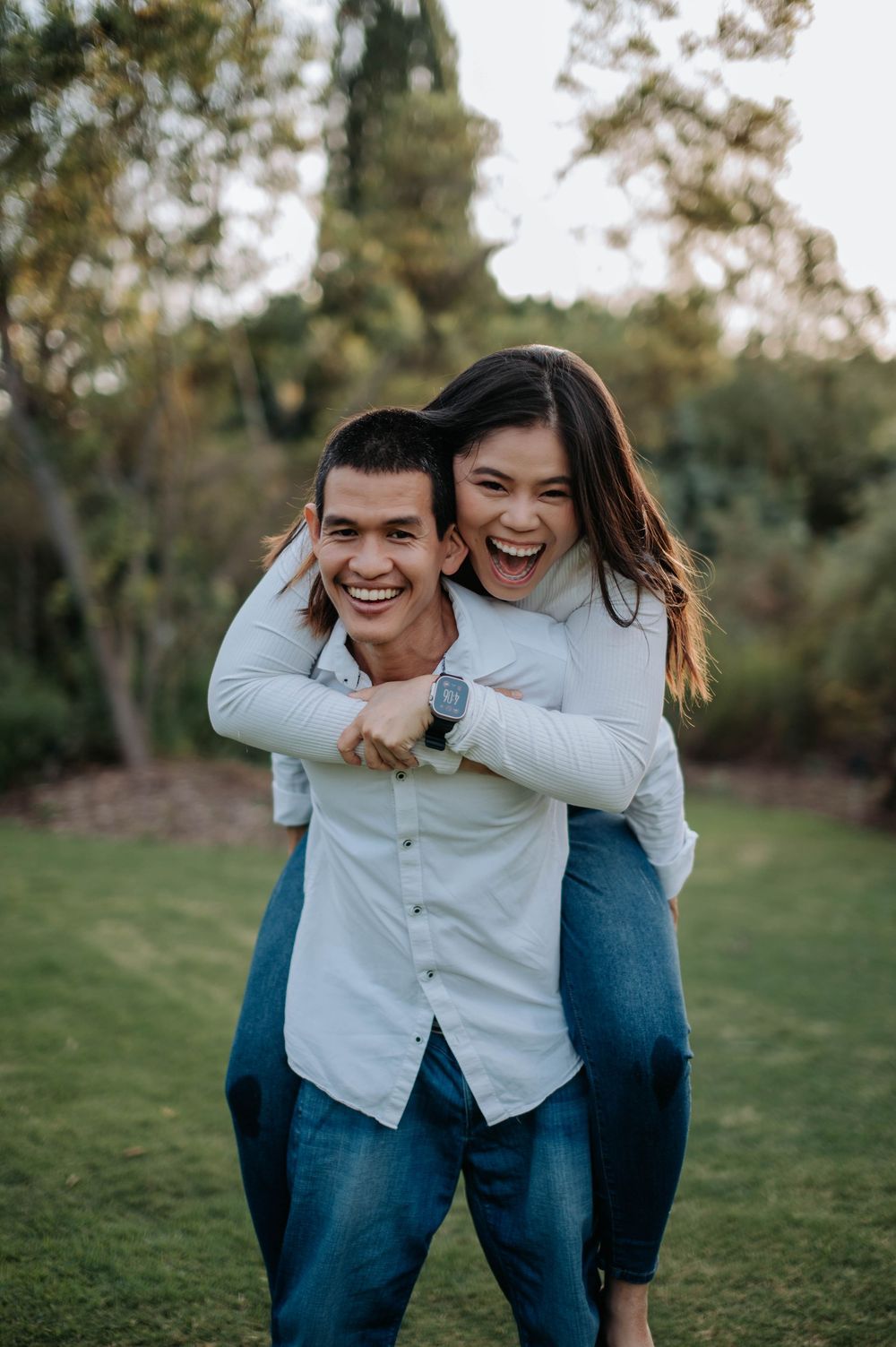 A joyful piggyback ride outdoors with laughter and smiles in a natural setting.