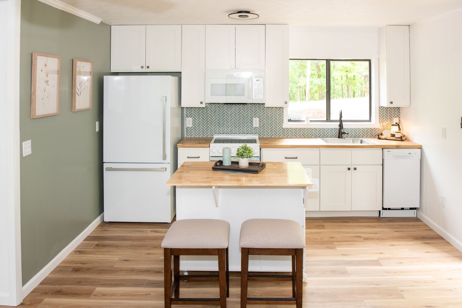 Open concept living space with white walls and hardwood floors in minimalist modern design.