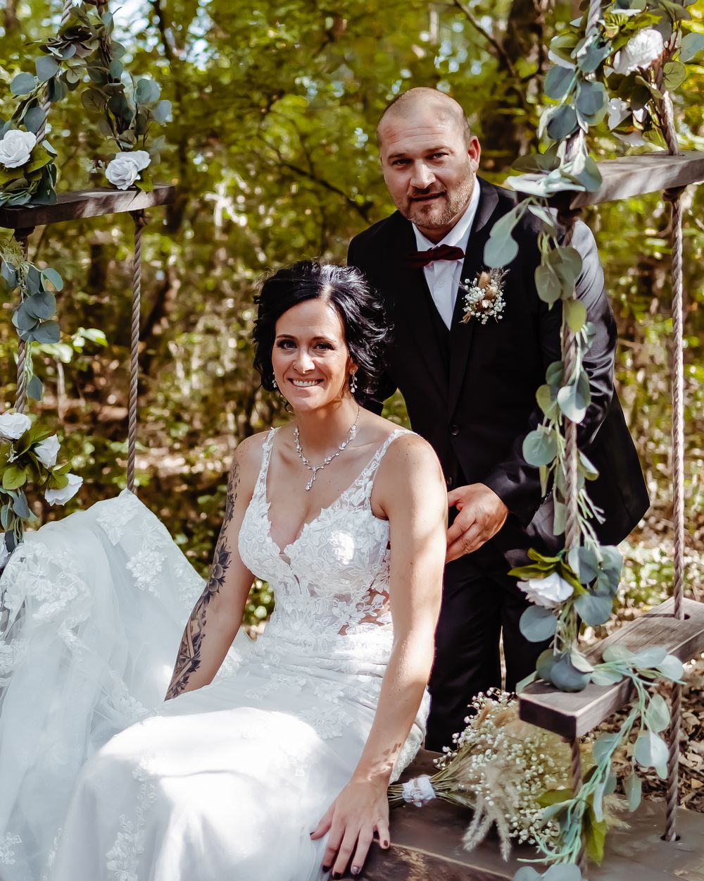 Wedding scene with decorative eucalyptus garland and elegant white lace gown.