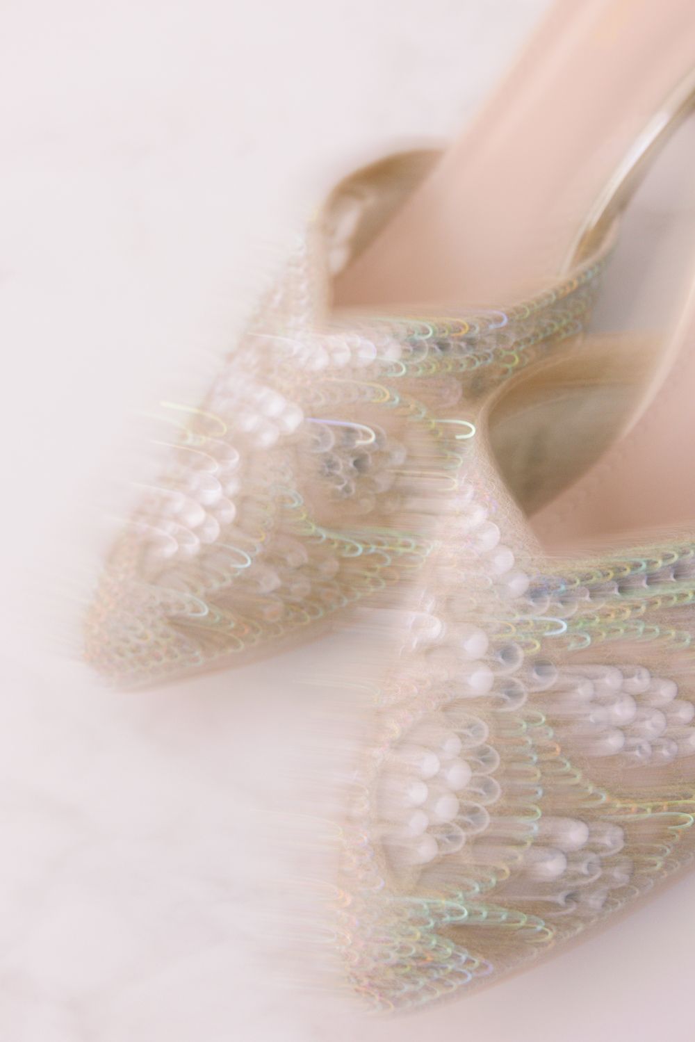 Elegant bridal shoes with delicate pearl and crystal embellishments in a soft focused ethereal style.