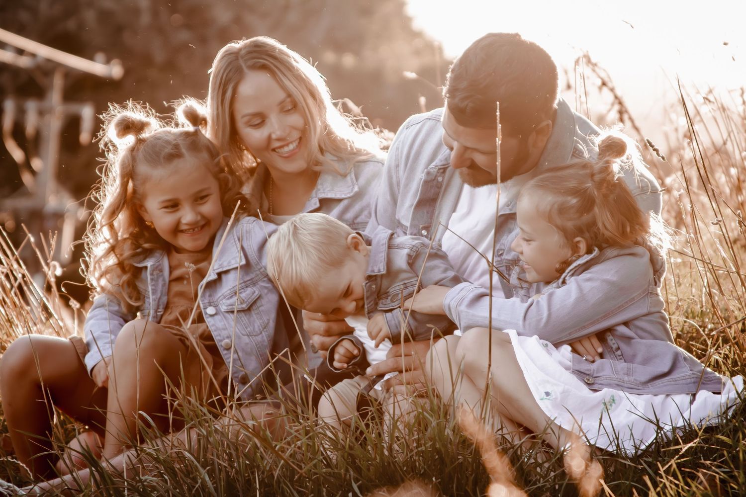 Family Laughing and hugging together at sunset