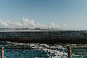 Wide cinematic frame of couple walking away from the lighthouse