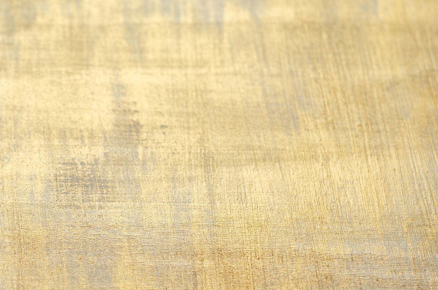 Abstract golden textured background with brushed metallic effect.