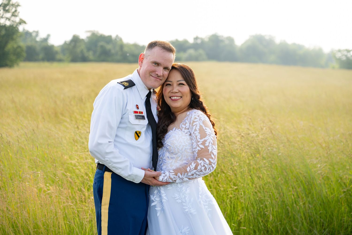 A romantic couple poses in a golden wheat field during sunset for engagement photos.