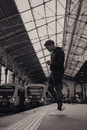 Silhouette of person jumping at train station platform.