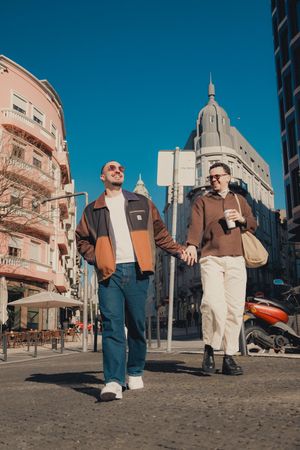 Series of street portraits showing walking movements against an urban backdrop with pink buildings.