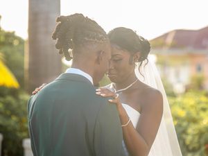 A tender moment between a couple on their wedding day during golden hour at an outdoor venue.