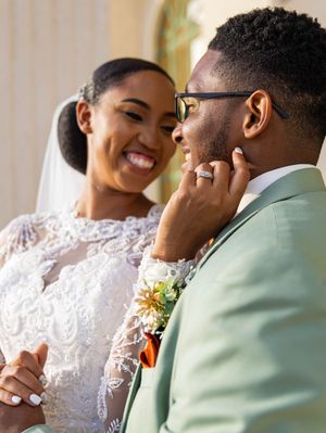 A wedding couple shares an intimate moment in their mint green and white attire during their special day.