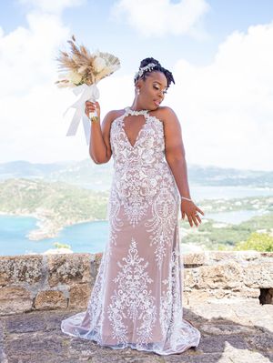 Elegant lace wedding gown with illusion details and sweeping sheer overlay photographed against scenic mountain backdrop.