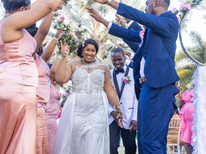 A joyous wedding celebration with guests cheering and dancing in colorful formal attire.