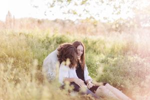 Couple sharing tender moment in sunlit summer meadow.