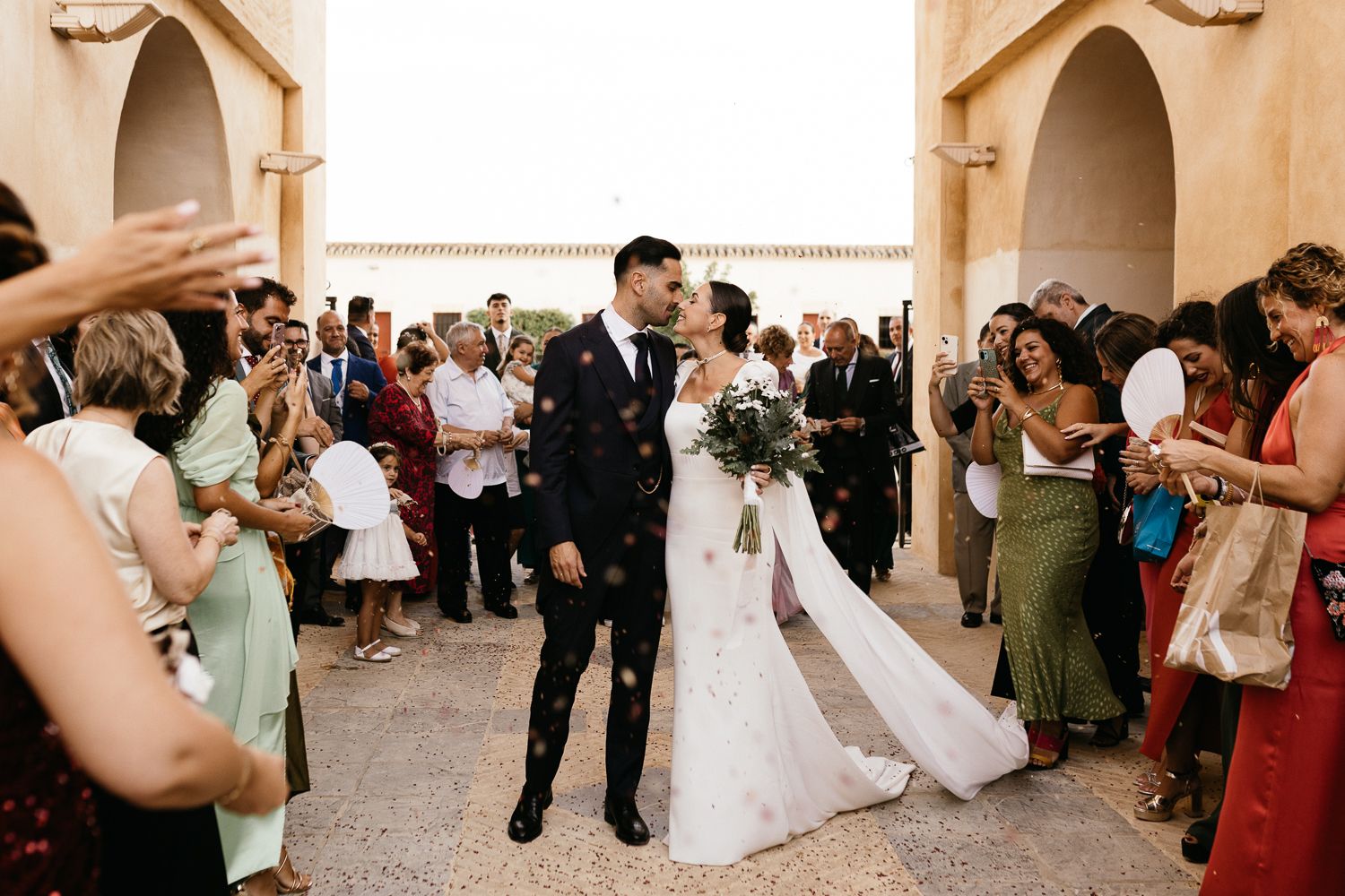 Wedding celebration at a Spanish-style venue with guests gathering outdoors.