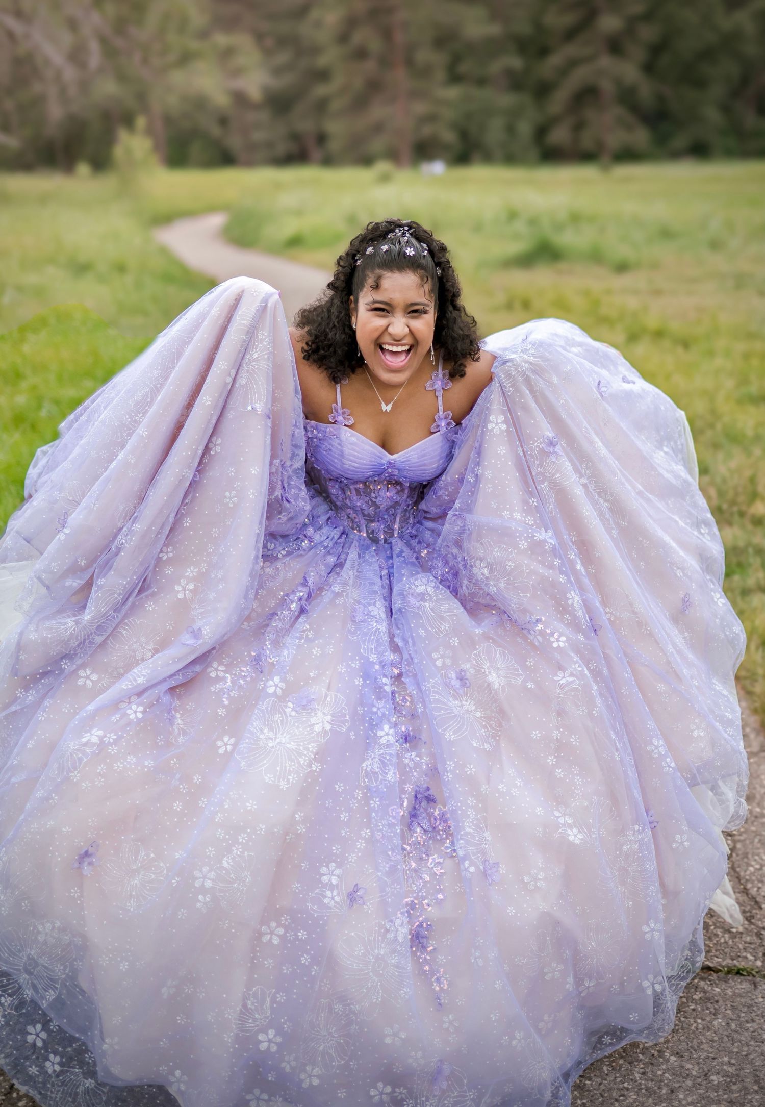 A girl laughs as she swishes her broad Quinceanera dress, in Yosemite