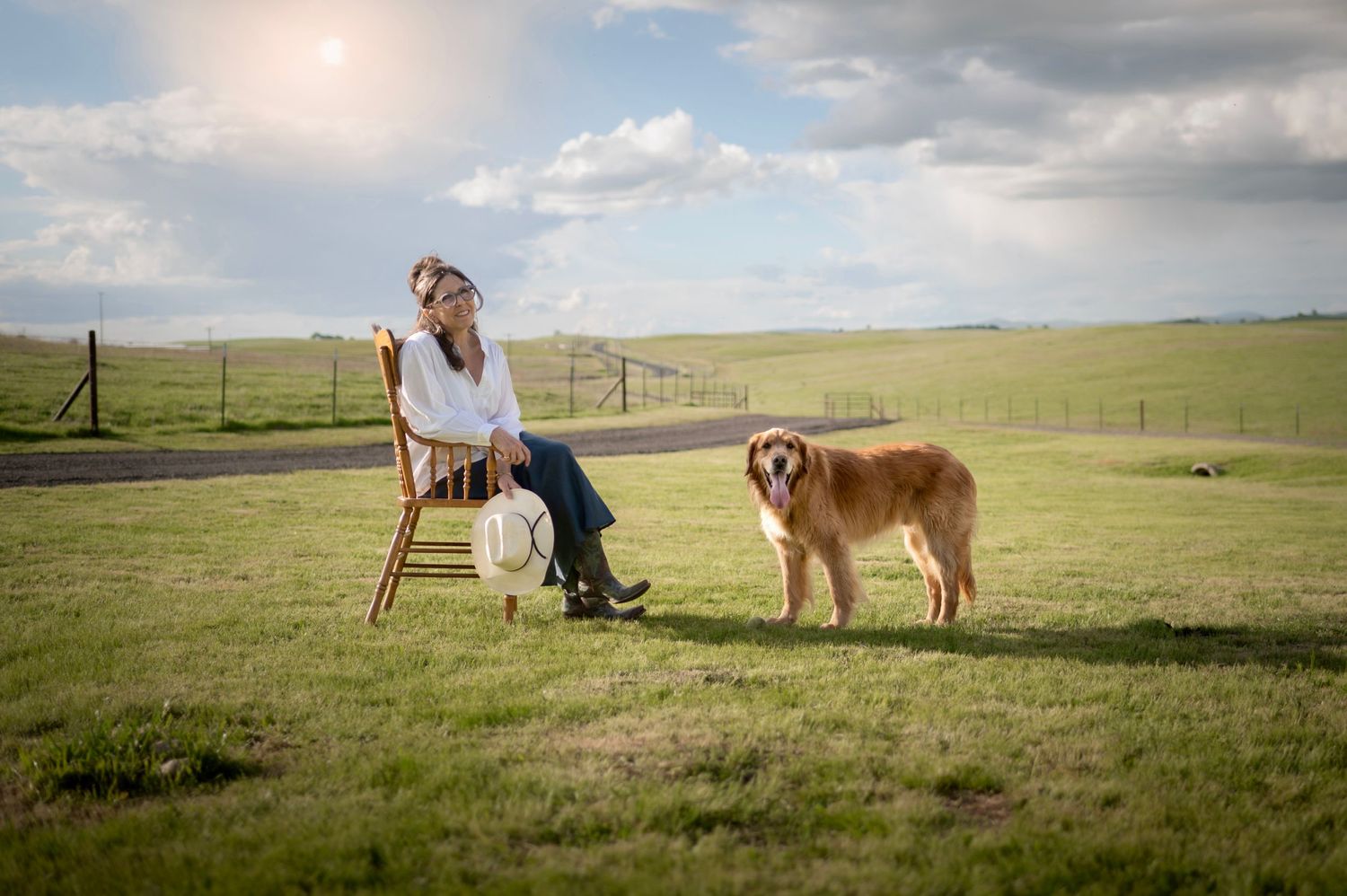 A woman relaxing with her senior dog, in a field