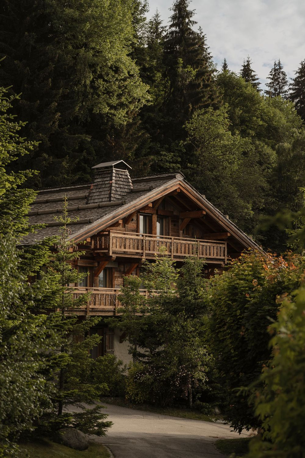 Traditional wooden mountain chalet exterior nestled in a pine forest — alpine architecture photography — Paul Brechu