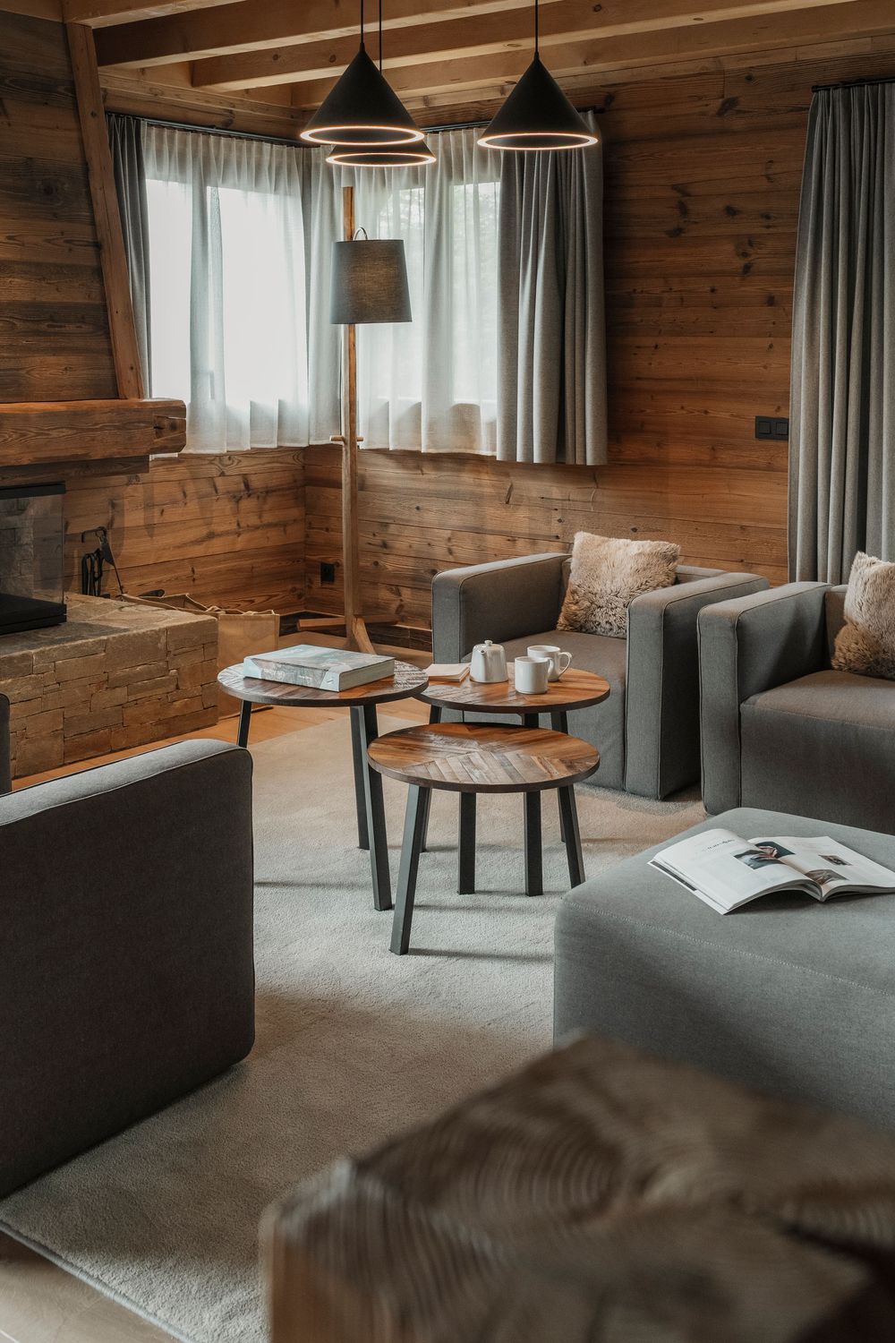 Luxury chalet interior with warm wood tones, soft seating area, and natural window light — interior architecture photography — Paul Brechu