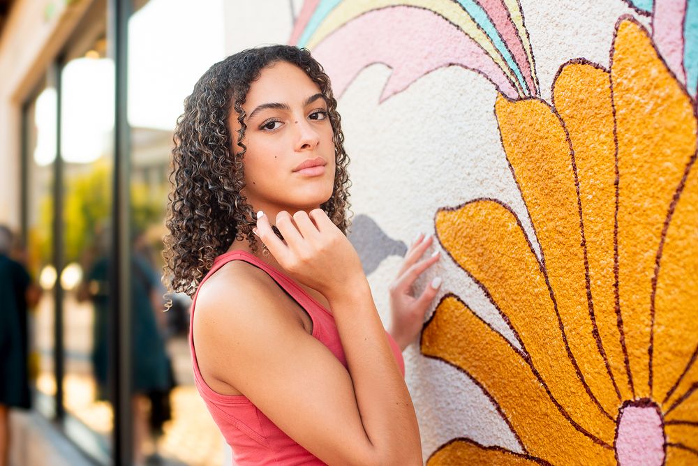 Kansas City Plaza colorful high school senior girl fashion forward portrait posing with flower mural on wall