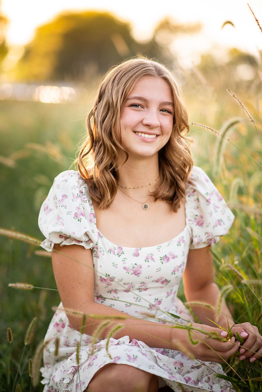 high school senior girl wearing a summer dress posing at wildflower field in kansas city missouri during golden hour