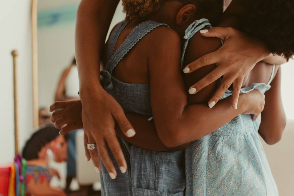 Close-up of hands embracing in gentle, intimate moment.