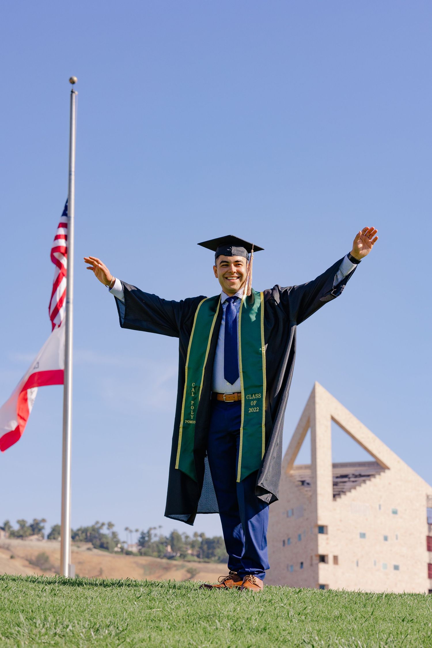 College graduate in front of the iconic 
CLA building at Cal Poly Pomona