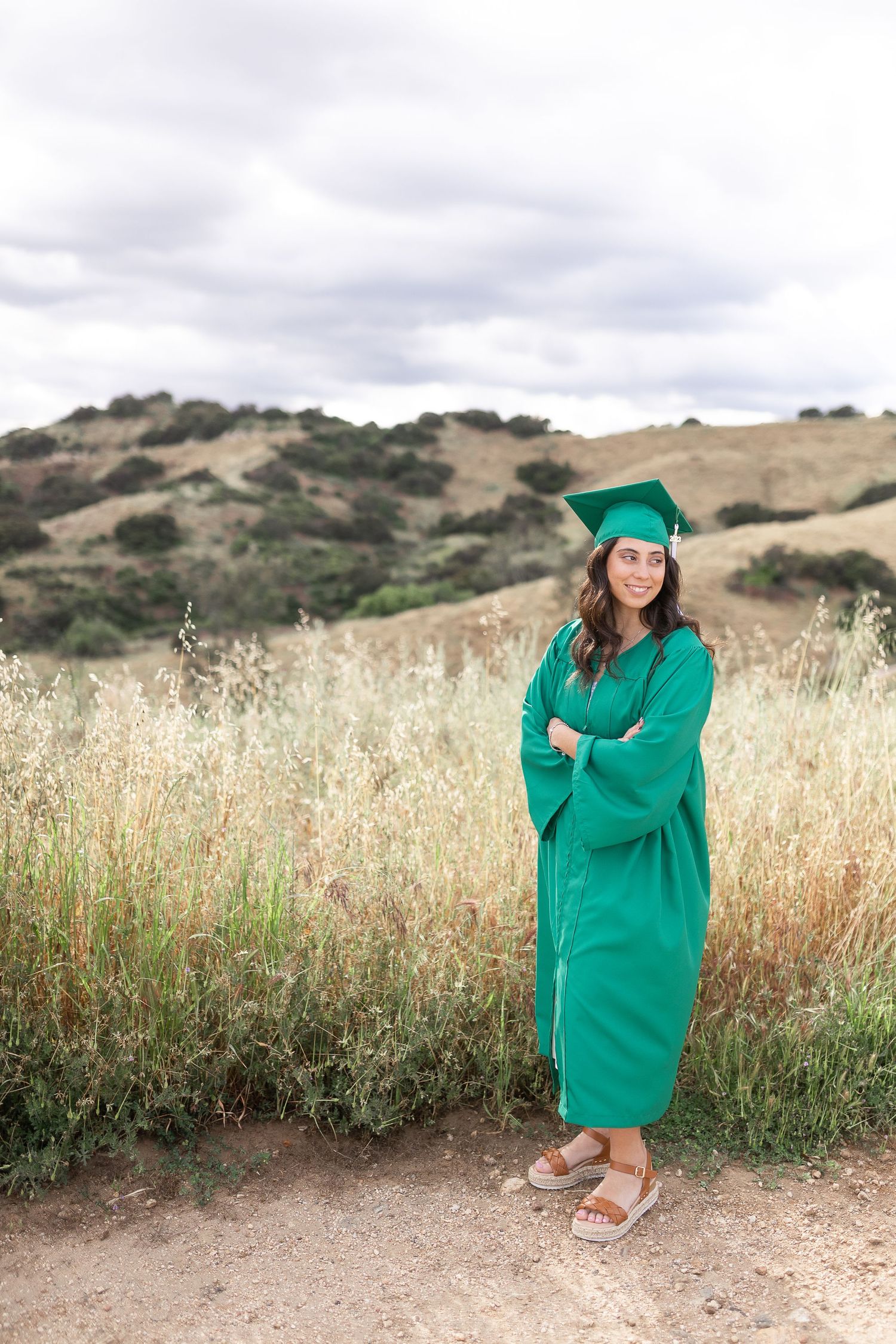 Senior girl crossing arms on a dirt road outside