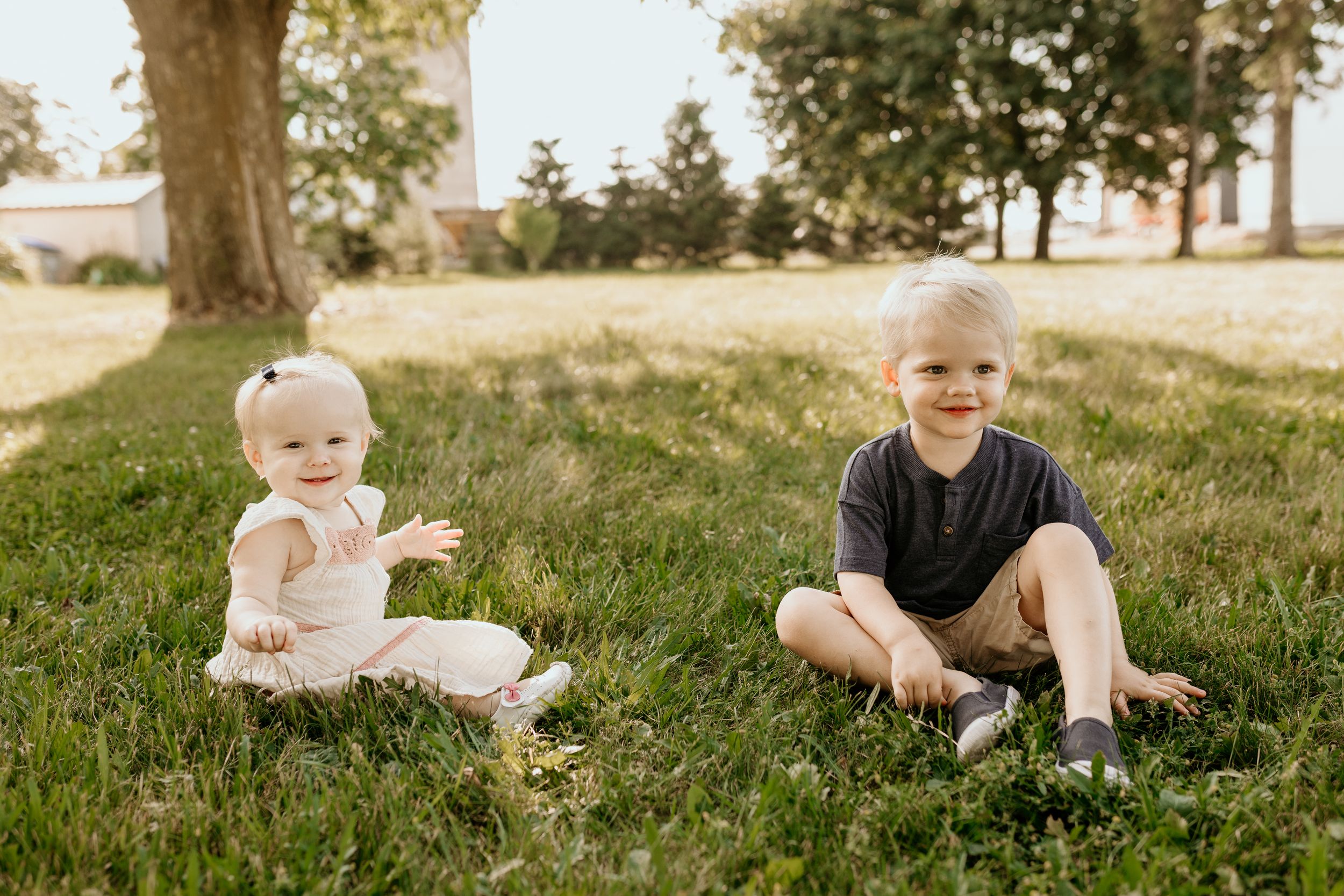 A series of candid outdoor photos showing a baby sitting and playing on grassy ground in warm sunlight.