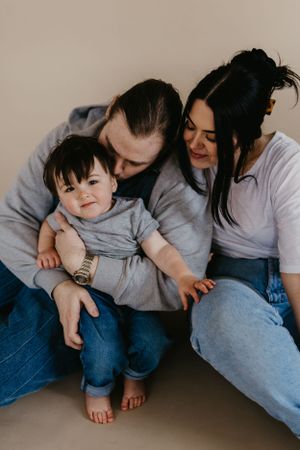 Intimate family portrait in matching grey and denim casual wear.
