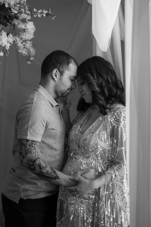 Intimate black and white portrait of expectant couple sharing a tender moment.