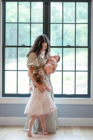 A touching family moment captured by large windows in soft natural light.