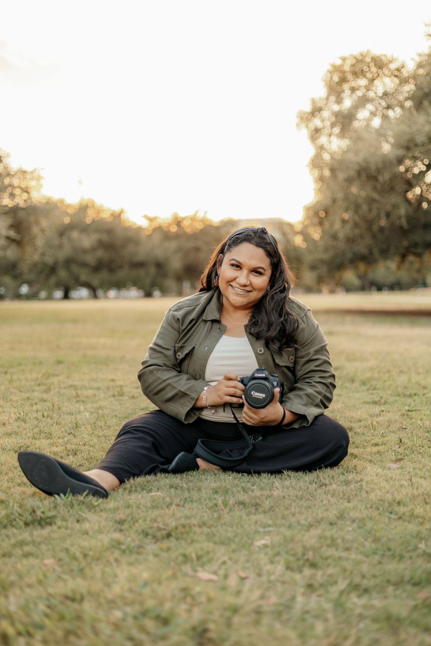 A photographer in a button-down shirt showing their camera.