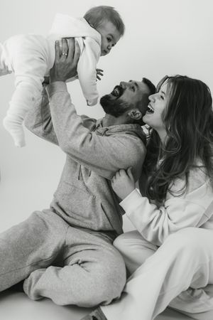 A romantic black and white photo series showing a couple in cozy loungewear sharing intimate moments together.