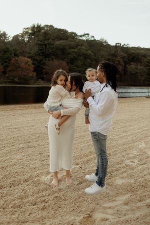 A family shares tender moments together in a field during a warm autumn day.