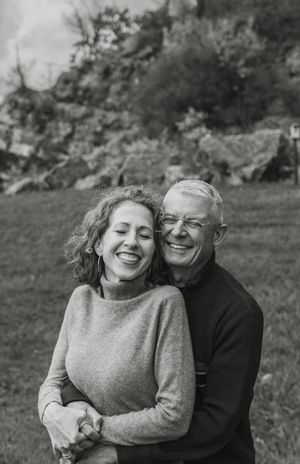Candid black and white photo series showing a couple embracing and laughing together outdoors in a natural setting.