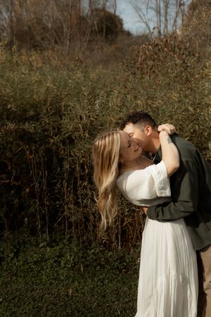 A couple in formal attire share intimate moments in a series of romantic outdoor photos against a natural backdrop.