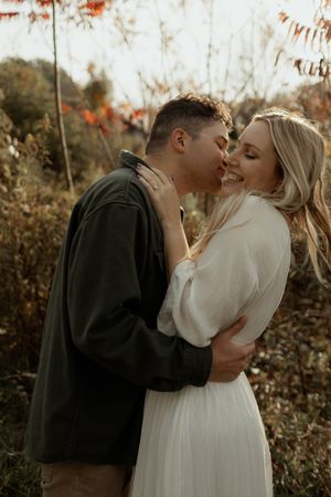 Romantic autumn engagement photoshoot series showing couple embracing in warm natural lighting among fall foliage.